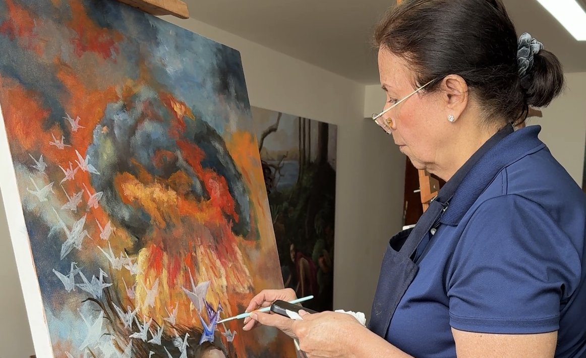 pintura-taller Artista pintando un retrato con grullas de papel